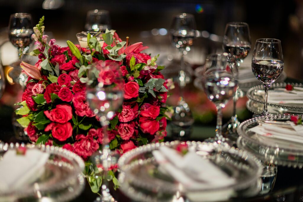 A beautiful table setting featuring red roses and crystal glassware for a sophisticated event.
